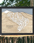 Laser cut wooden trail map of Ski Santa Fe Ski Resort on a wooden stump with a natural background