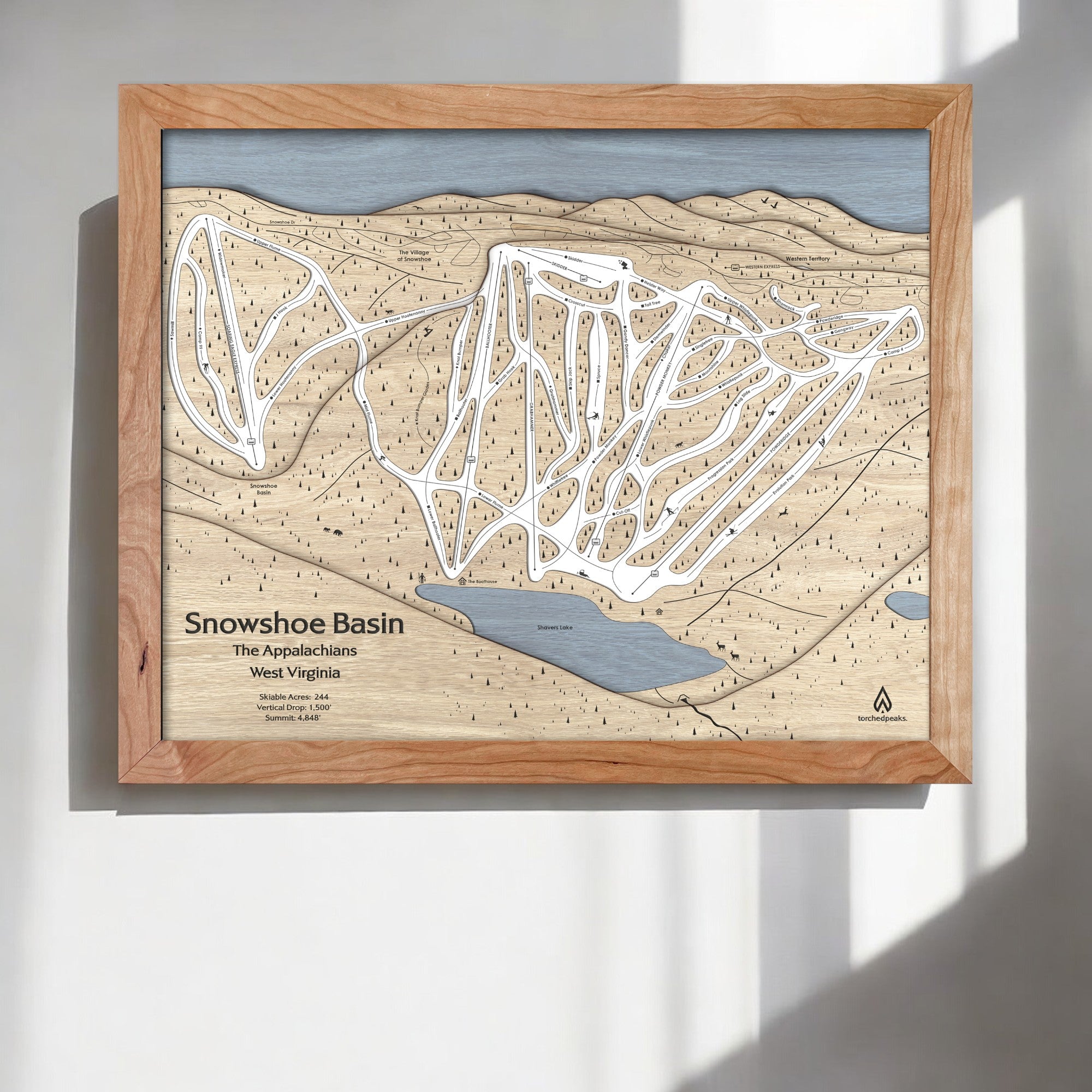 Wooden framed map of Snowshoe Mountain Ski Trails on a white wall in a ski cabin.