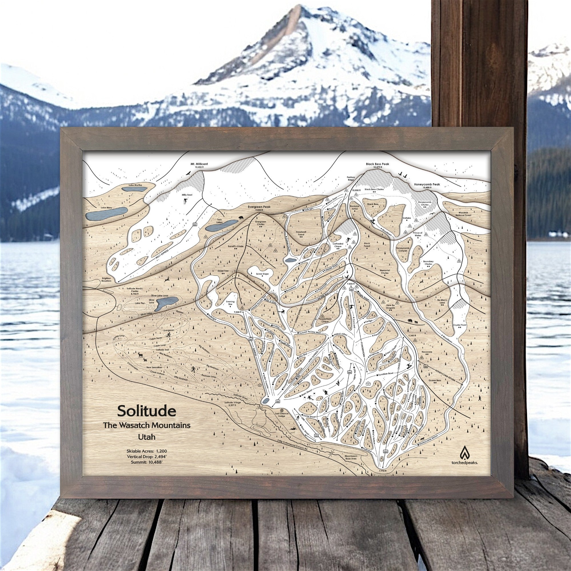 Framed ski resort map of Solitude, Utah with a mountainous landscape in the background.