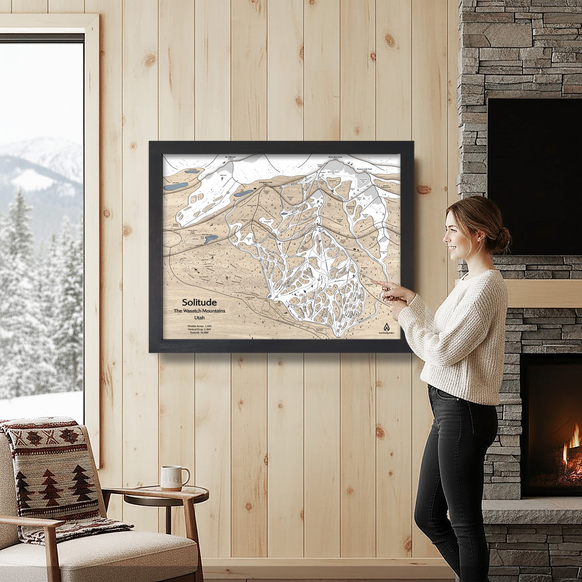 Woman looking at a framed ski trail map of Solitude mountain in a cozy living room.