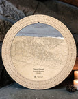 Birch Steamboat ski trail map wooden cribbage board displayed by a stone fireplace with candles and pinecones.