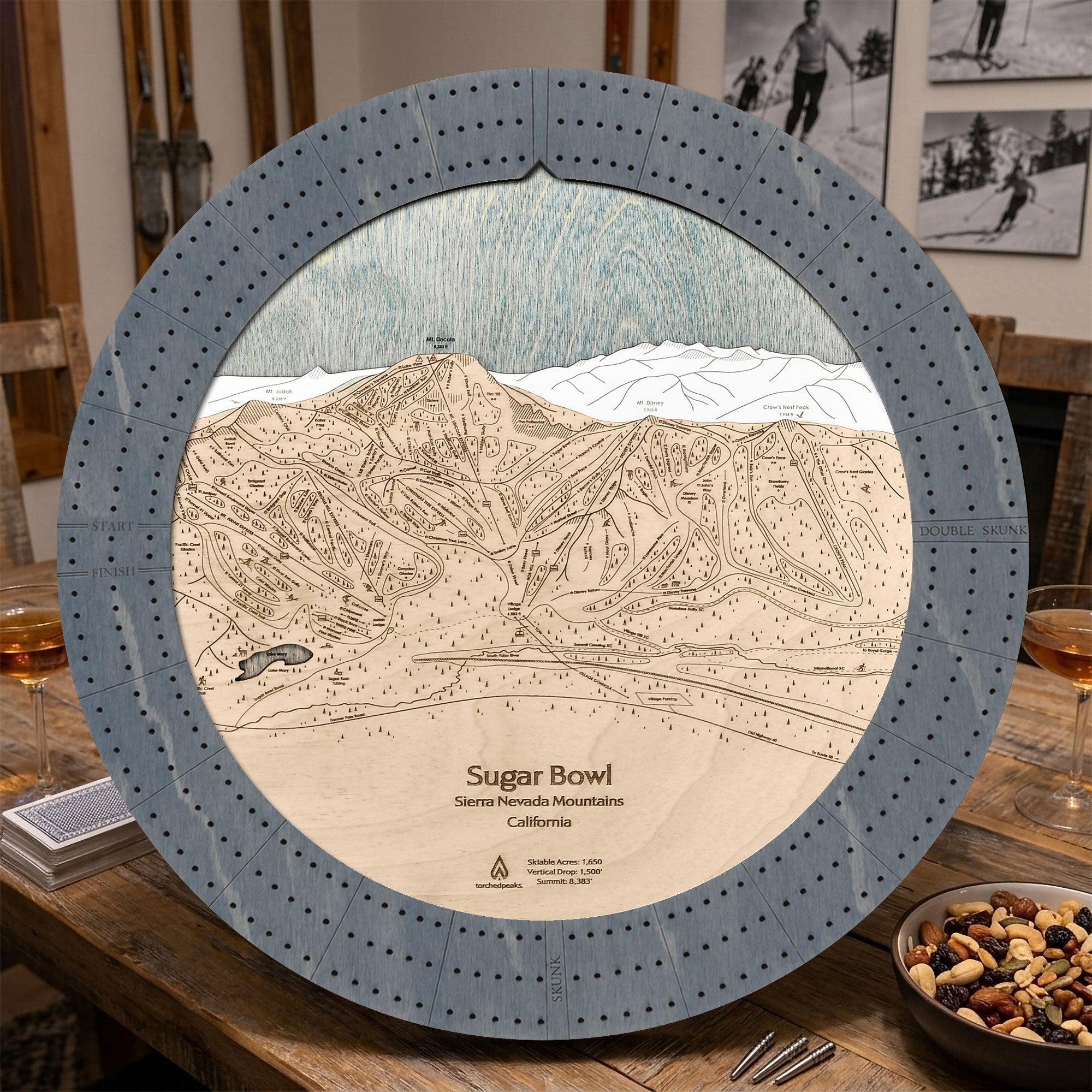Sugar Bowl ski map cribbage board in Graphite Grey styled on a wood table.