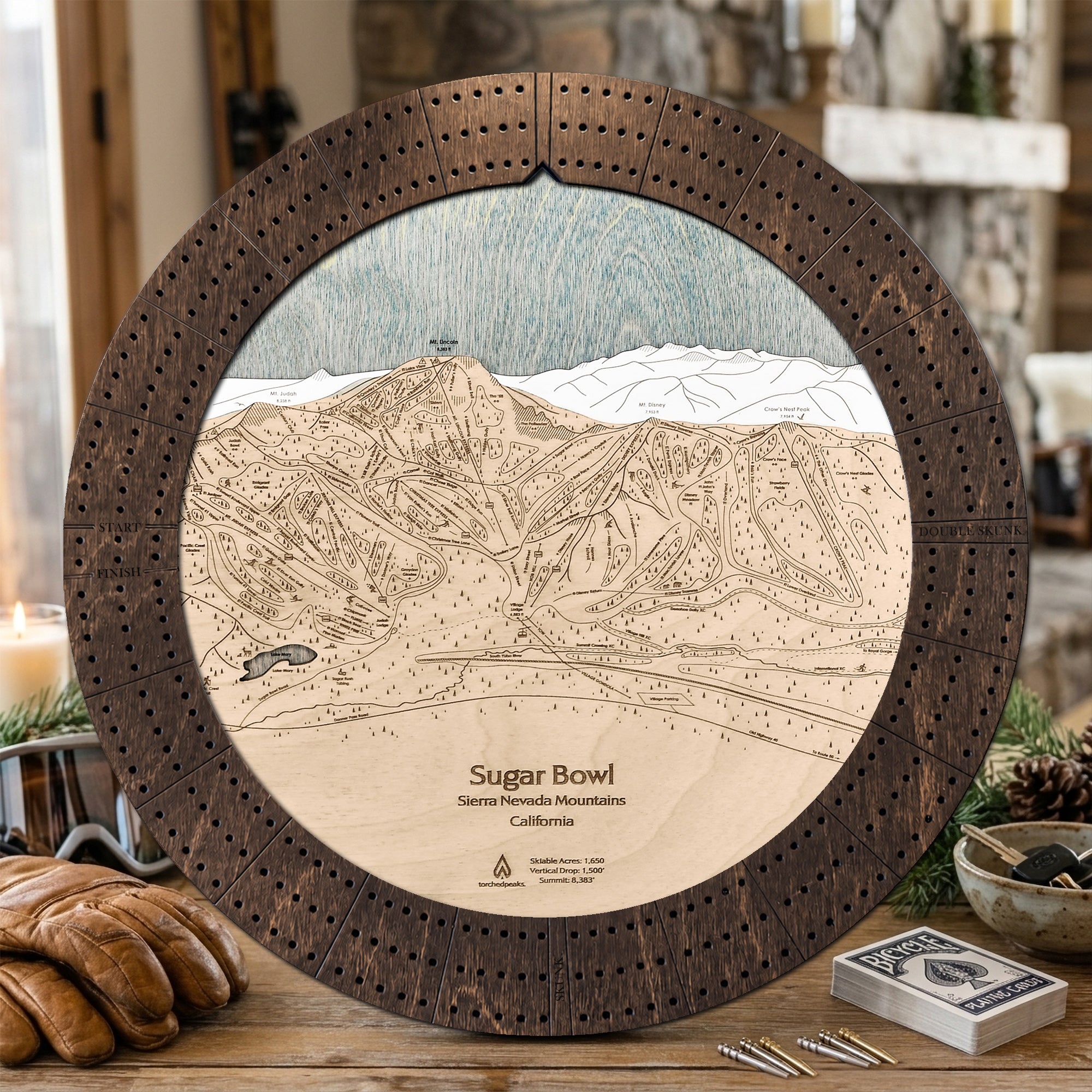 Sugar Bowl ski trail map cribbage board in Rustic Mocha styled on a cabin table.