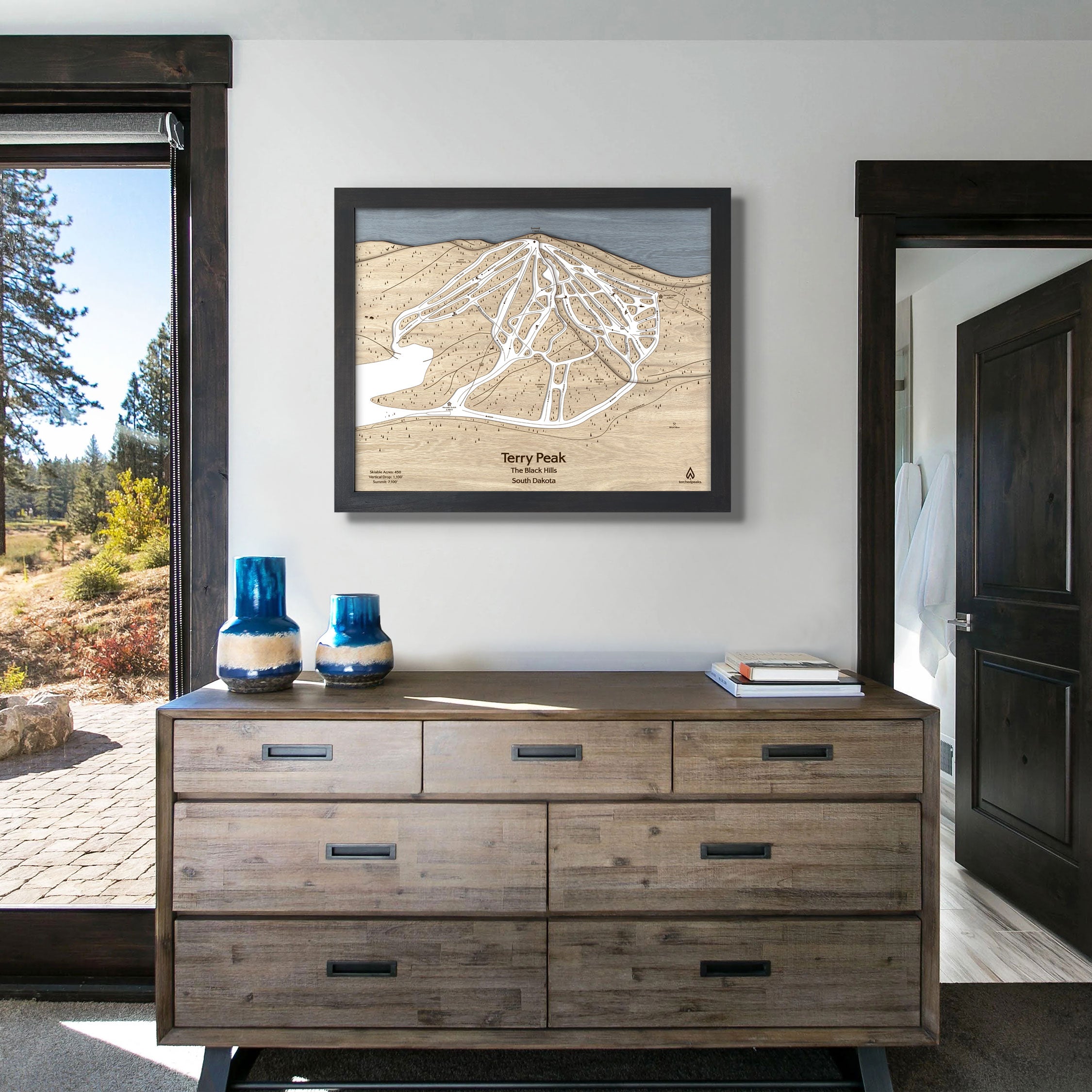 Framed Terry Peak ski resort map on a white wall in a modern ski house. 