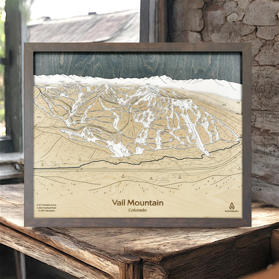 Framed topographic map of Vail Mountain, Colorado on a wooden surface.