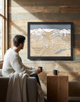 Whistler Blackcomb 3D wood ski map displayed with a second framed trail map on a rustic wood cabin wall