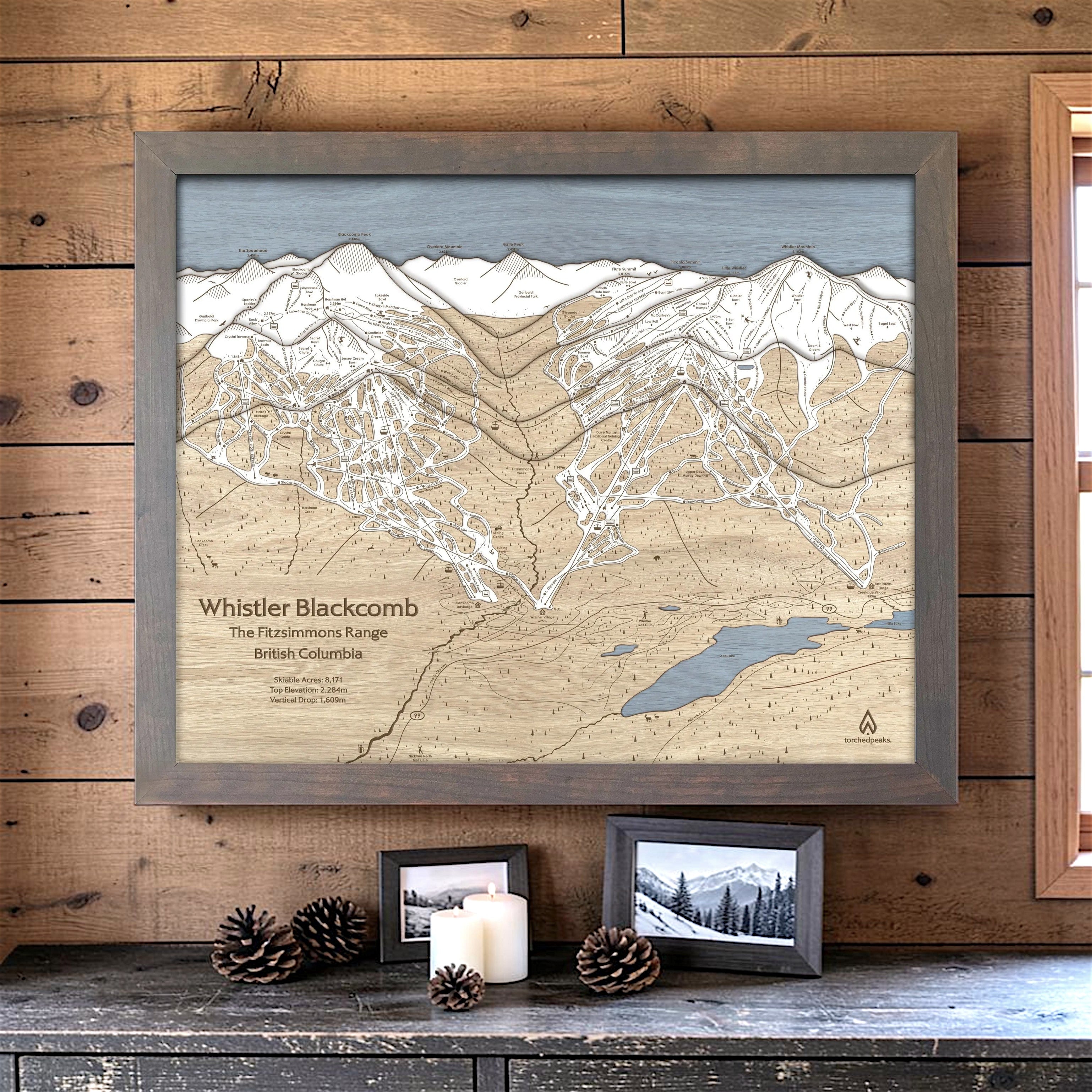 Storm Grey-framed Whistler Blackcomb wood ski map displayed on a warm timber wall with restrained cabin décor.
