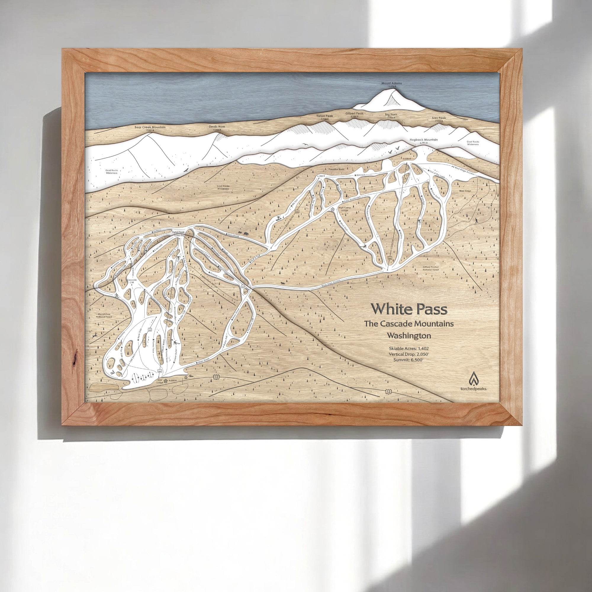 Framed 3d wood map of White Pass Ski Trails in the Cascade Mountains, Washington, on a white wall in a modern ski cabin. 