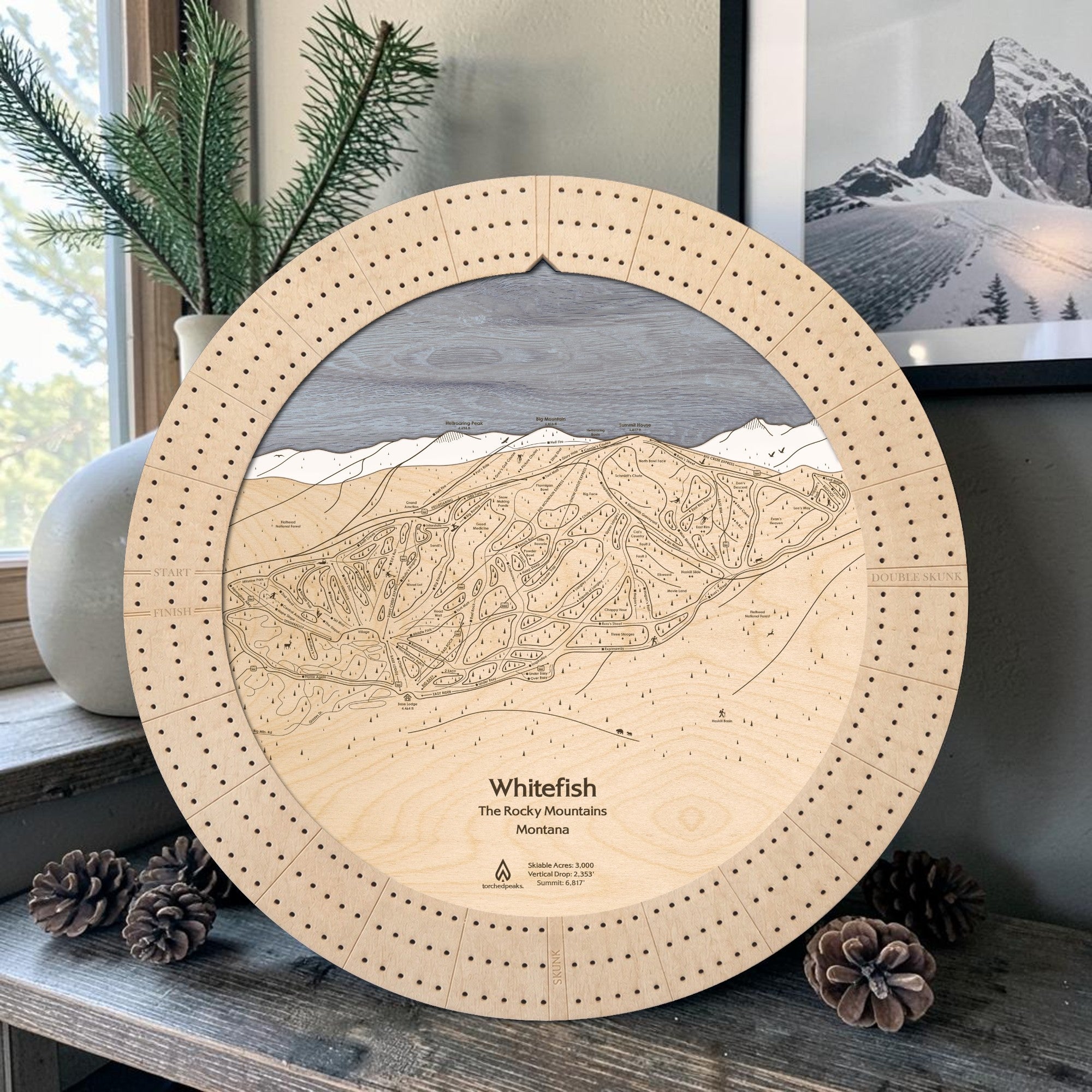 Birch Whitefish Mountain wooden cribbage board displayed with pinecones as rustic ski cabin décor.