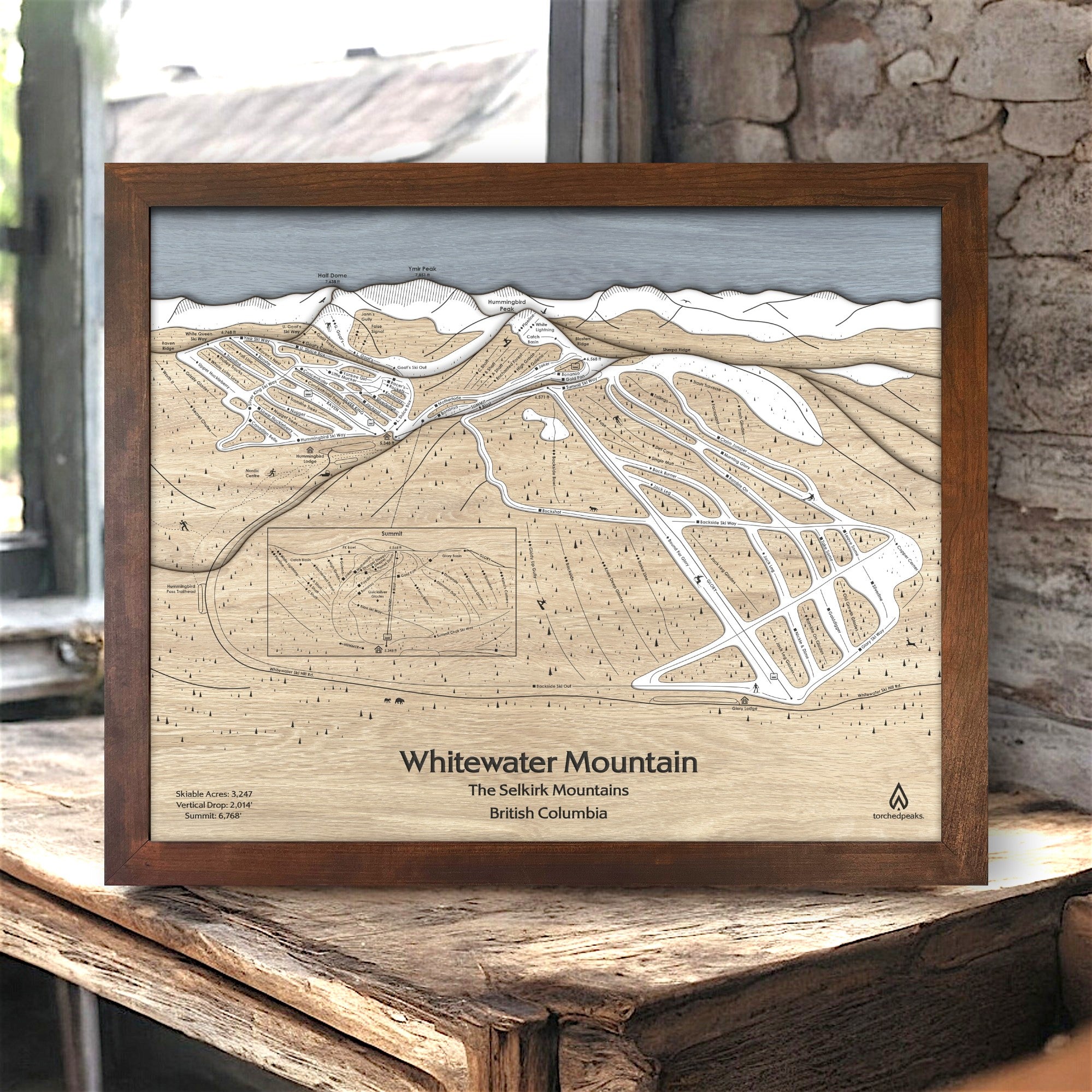 Framed wooden map of Whitewater Mountain Ski Resort in a wooden frame on a rustic surface in a rustic ski cabin. 