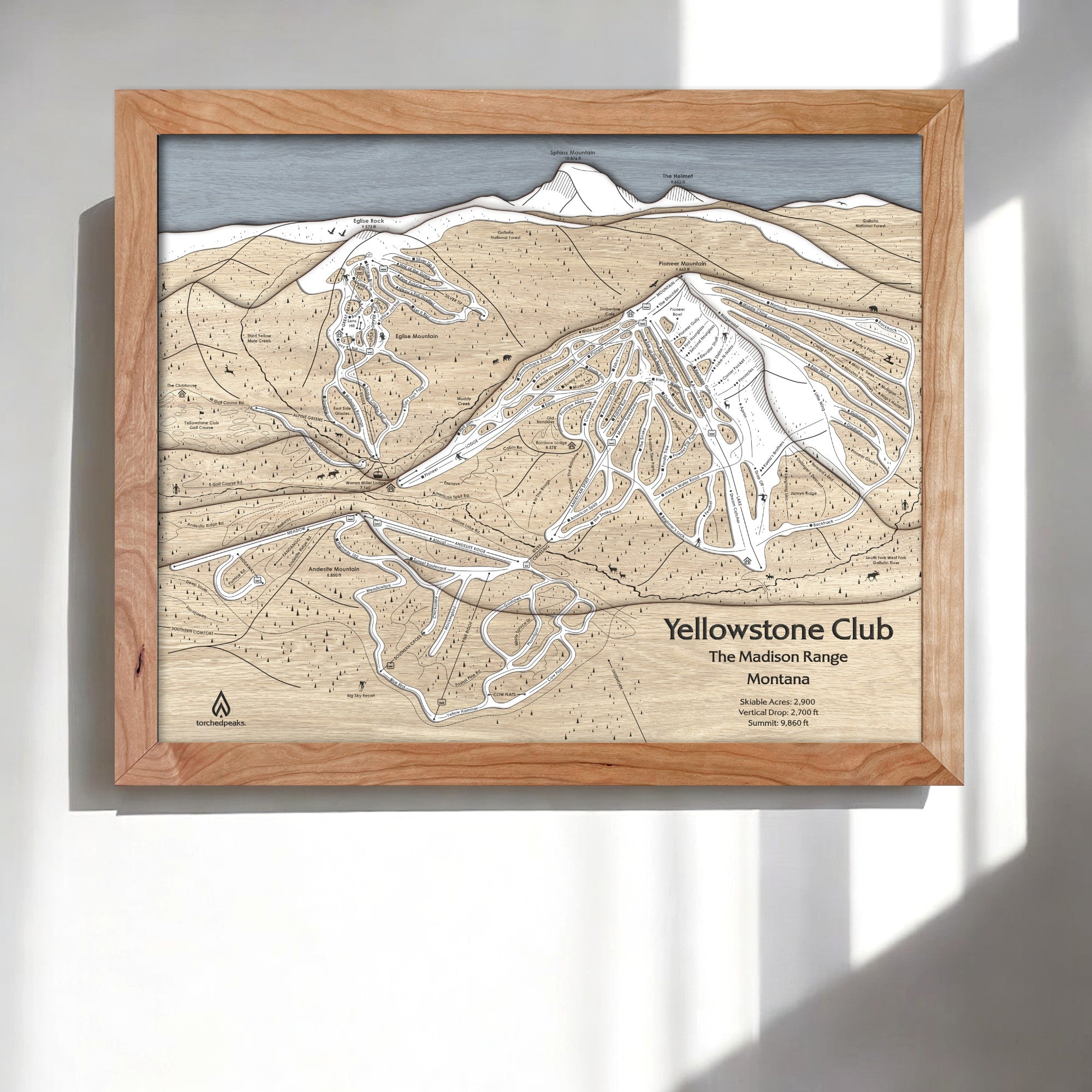 Framed three dimensional ski trail map of Yellowstone Club on a white wall in a modern ski chalet. 