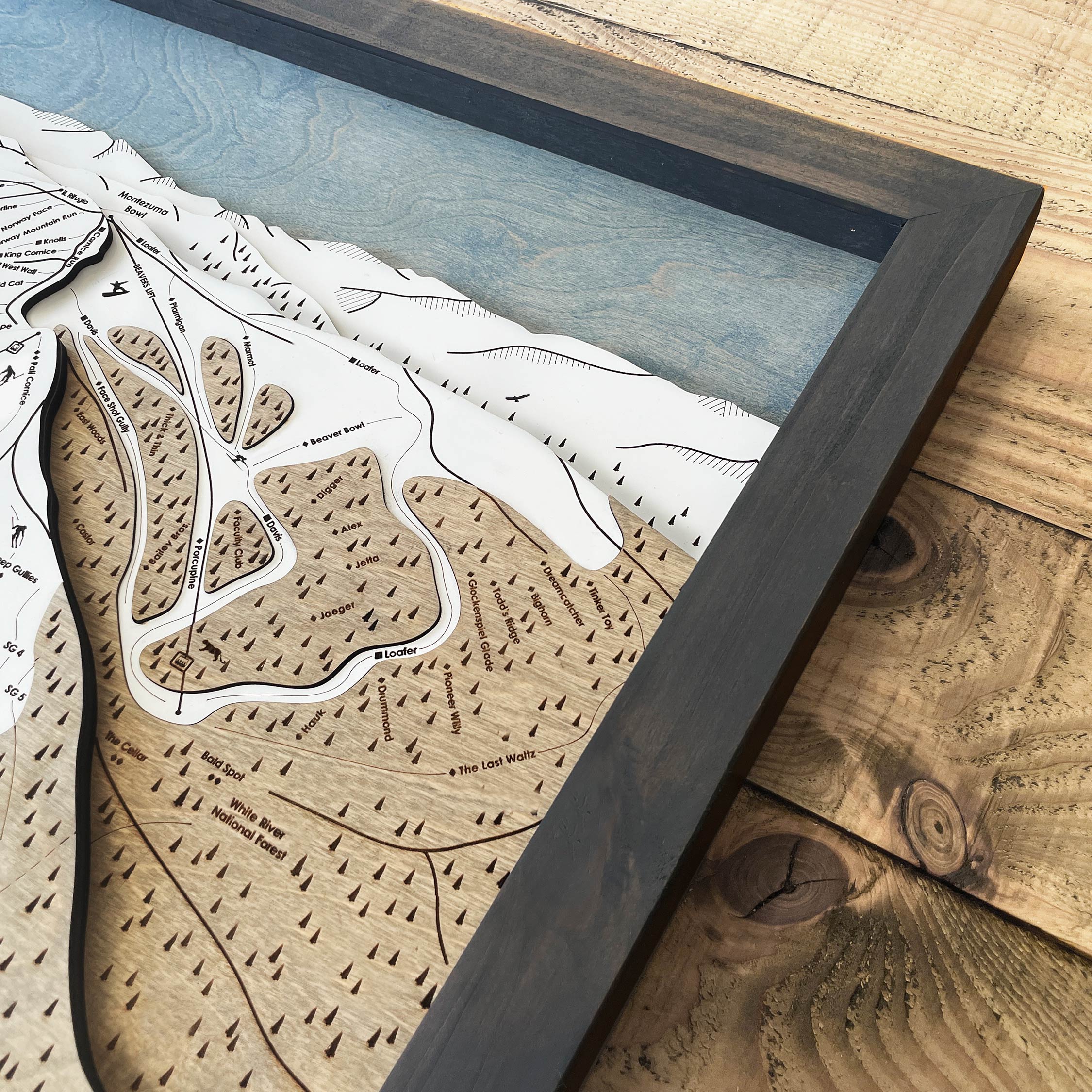 Wooden map of a ski resort with a detailed layout on a wooden surface