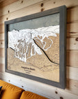 Framed topographic map of Arapahoe Basin Ski Resort on a wooden wall above a couch.