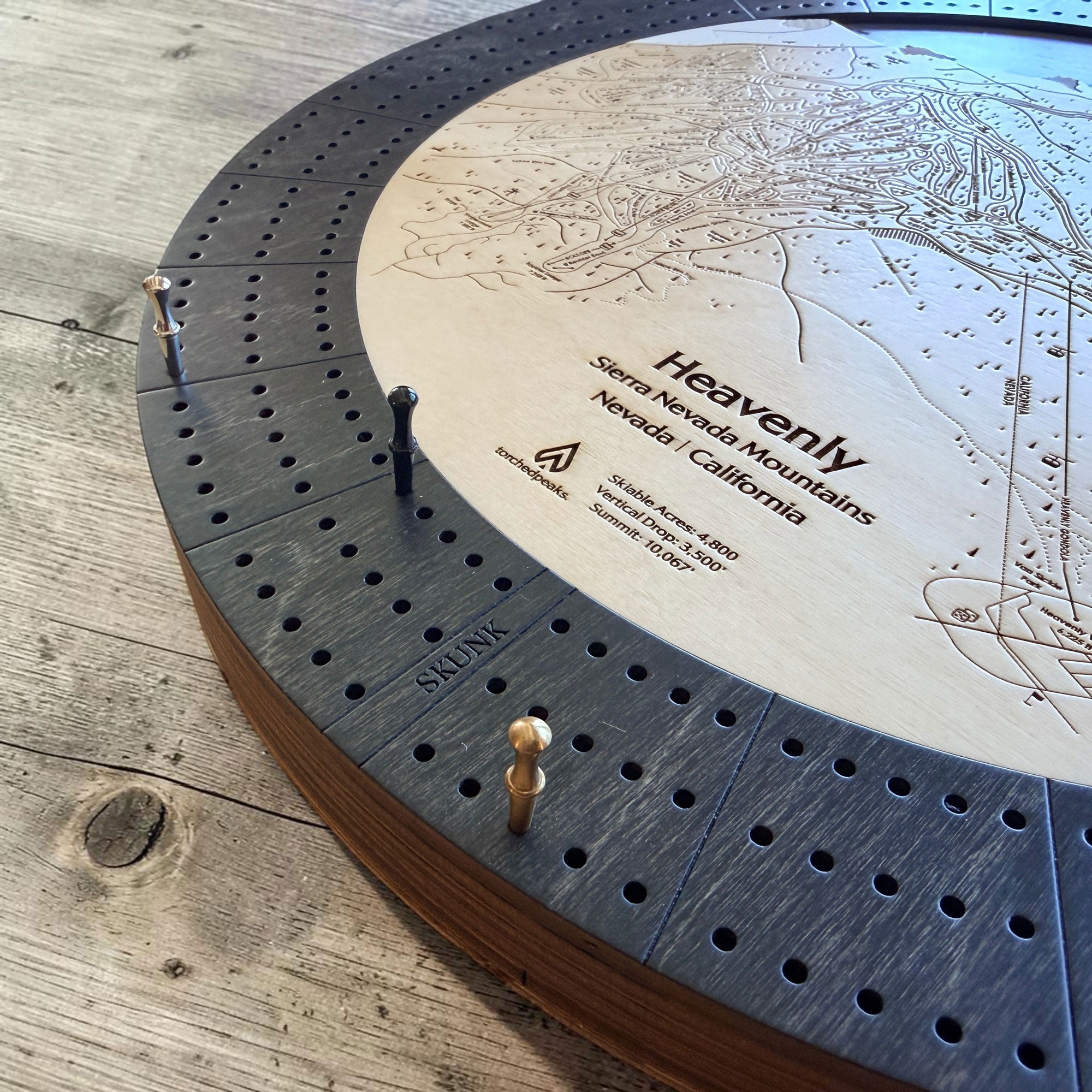 Angled close-up of the Heavenly Ski Map Cribbage Board highlighting engraved trails, three-track play, and premium wood construction.